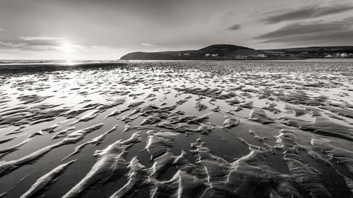 Scenic view of beach against sky on sunny day at croyde