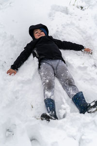 High angle view of boy lying on snow