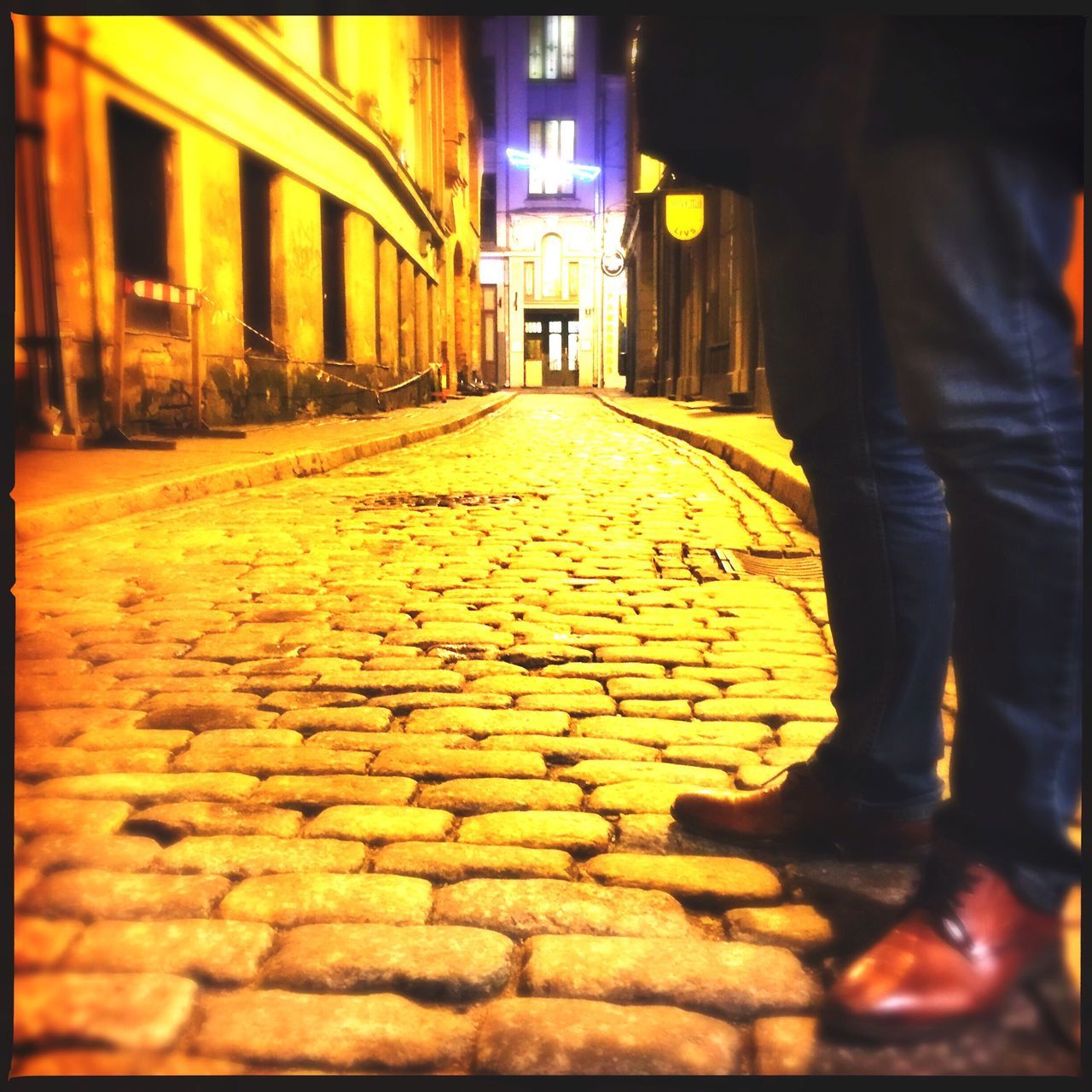 LOW SECTION OF MAN WALKING IN CITY AT NIGHT