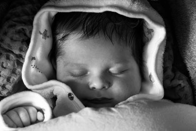 Close-up of cute baby boy sleeping on bed