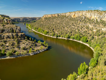 Scenic view of river amidst trees against sky