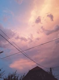 Low angle view of silhouette electricity pylon against sky during sunset