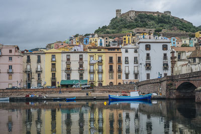 Boats in river with buildings in background