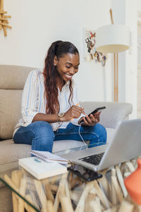 Young woman using mobile phone at home