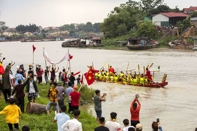 Group of people by boats in river