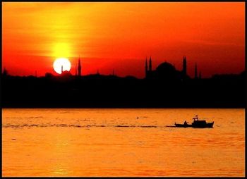 Boat sailing in sea at sunset