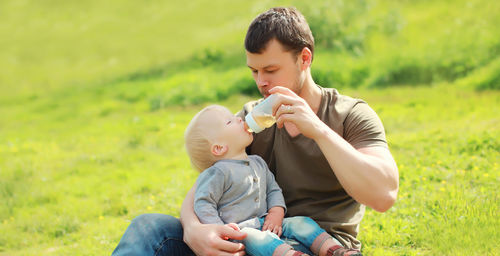Side view of mother and daughter on field