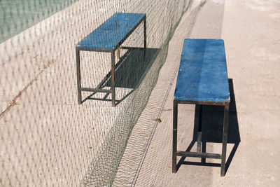 High angle view of chairs on table against building during sunny day