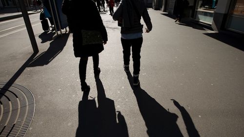 Low section of people walking on road