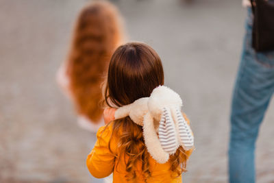 Rear view of mother with daughter standing outdoors