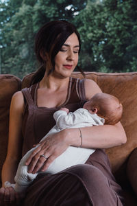 Midsection of mother and daughter sitting outdoors