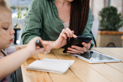 Busy successful mother and business owner with cell phone and tablet having breakfast with her