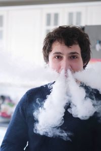 Portrait of young man smoking outdoors