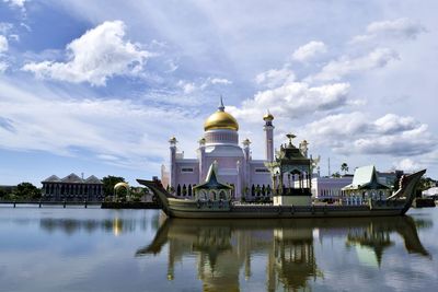 Reflection of building in lake against sky
