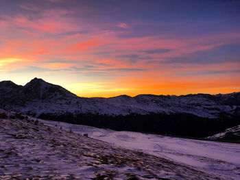 Scenic view of snowcapped mountains against sky during sunset