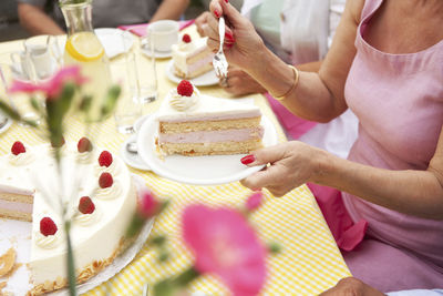 Hands putting cream cake on plates