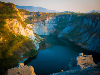 Scenic view of lake by mountains against sky