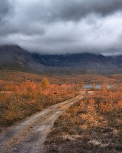 Road leading towards mountains against sky