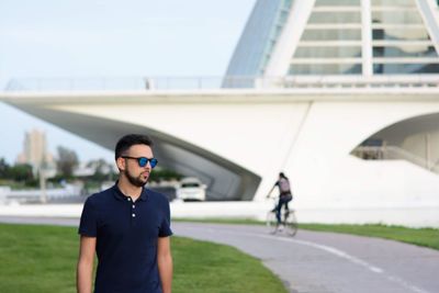 Young man in sunglasses standing in city