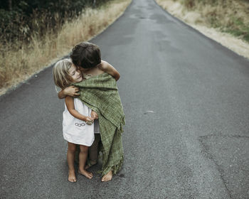 Brother kissing sister while standing on country road