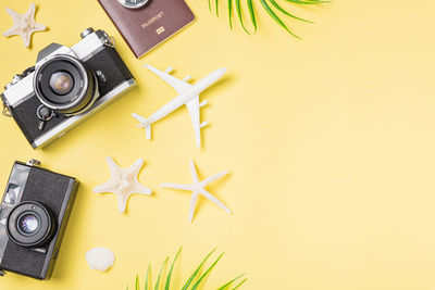 Top view mockup retro camera films, airplane, leaves, starfish traveler tropical beach accessories