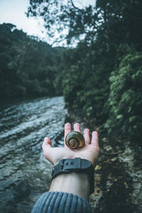 Low section of man holding woman against river