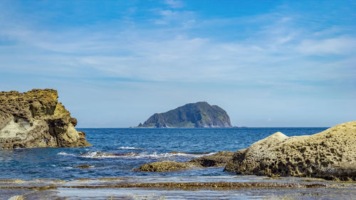 Rocks on beach against sky