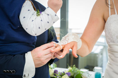 Midsection of wedding couple holding hands