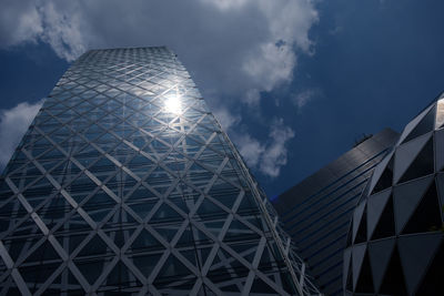 Low angle view of modern building against cloudy sky