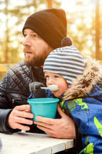 Little boy and dad eating outdoors. baby son and father having picnic. happy family together outside