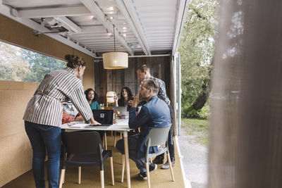 Businesswoman giving presentation to colleagues in portable office truck