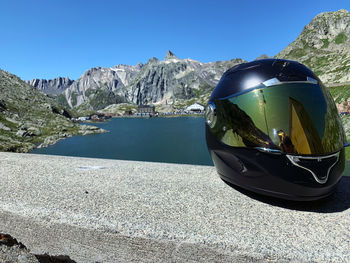 Crash helmet on retaining wall against mountains
