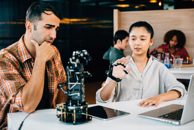 Young woman using mobile phone at table