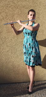 Portrait of woman standing against wall