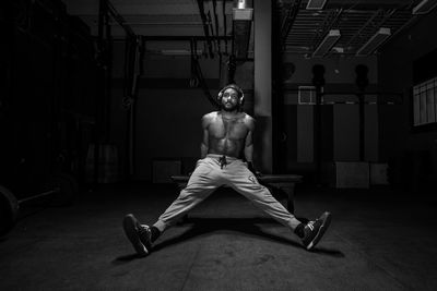 Portrait of shirtless man sitting in corridor