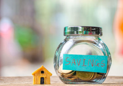 Close-up of coins in jar on wooden table