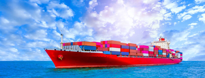 Red ship on sea against sky