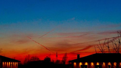 Silhouette buildings against sky at sunset