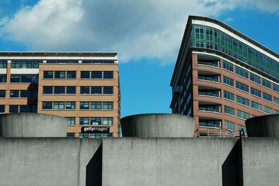 Low angle view of buildings against cloudy sky