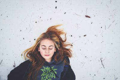 High angle view of teenager relaxing on snow covered field