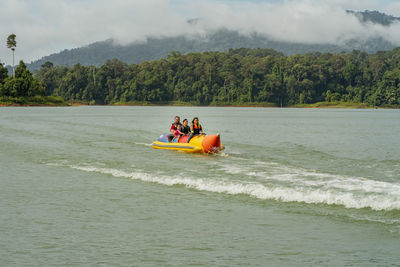 People in boat on sea against sky