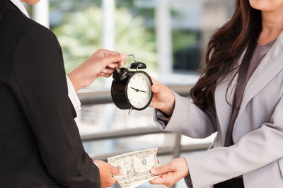 Midsection of woman holding umbrella at home