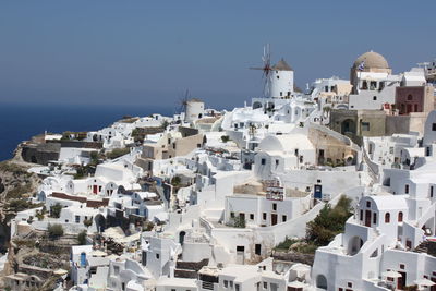 Aerial view of townscape by sea against clear sky