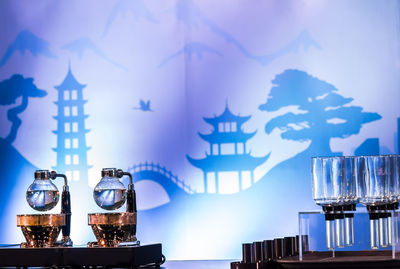 Close-up of illuminated lamp on table against building