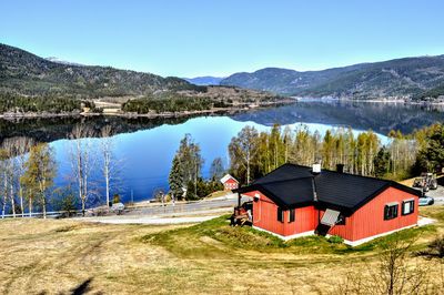 Scenic view of lake and mountains against clear blue sky