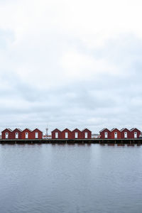 Buildings by lake against sky