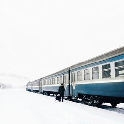 Man on snow covered landscape against clear sky
