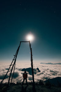 Rear view of man standing on snow covered field against sky