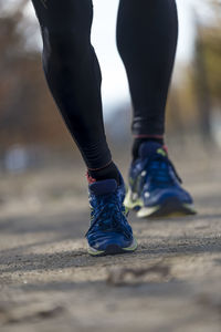 Low section of man walking on road