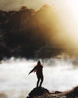 Silhouette man standing on mountain against sky during sunset